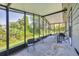 Relaxing screened porch with seating area overlooking a lush green yard with mature trees at 878 Fawnspring Ct, Englewood, FL 34223