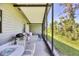 Outdoor space featuring a screened-in porch with a grill, seating and backyard views at 878 Fawnspring Ct, Englewood, FL 34223