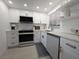 Close-up view of the renovated kitchen featuring stainless steel appliances and white marble countertops at 95 Coquina Ln, Englewood, FL 34223
