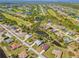 Panoramic aerial shot displays houses near a golf course and waterways with lush greenery in the vicinity at 116 Tournament Rd, Rotonda West, FL 33947
