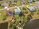 Aerial view of a residential neighborhood featuring single-Gathering homes, pools, and lush landscaping near waterways at 116 Tournament Rd, Rotonda West, FL 33947