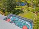 Aerial view of a screened-in pool, landscaped backyard with garden, and serene pond at 116 Tournament Rd, Rotonda West, FL 33947