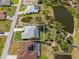 Aerial view of a single-Gathering home with a screened-in pool and lake views, surrounded by lush landscaping at 116 Tournament Rd, Rotonda West, FL 33947