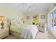 Cozy bedroom with a ceiling fan, a comfortable chair, and a view of lush greenery at 116 Tournament Rd, Rotonda West, FL 33947
