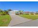 Charming home with a long driveway, vibrant landscaping, and well-maintained lawn at 116 Tournament Rd, Rotonda West, FL 33947