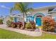 Charming home with vibrant blue trim, lush landscaping, and a welcoming entrance at 116 Tournament Rd, Rotonda West, FL 33947