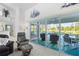 Living room features a sliding glass door to a patio with chairs, a table, and a pool at 116 Tournament Rd, Rotonda West, FL 33947