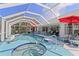 The screened-in pool with a hot tub and patio furniture is perfect for relaxation and entertainment at 116 Tournament Rd, Rotonda West, FL 33947