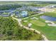 Beautiful aerial view of a community pool and amenity center, tennis courts and a golf course at 12470 Wellen Golf St # 108, Venice, FL 34293