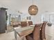 Open dining room with stylish wicker chairs and decorative light fixture leading into the living area at 12470 Wellen Golf St # 108, Venice, FL 34293