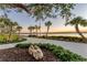 Scenic walking path with palm trees and lush landscaping, offering tranquil waterfront views at 12470 Wellen Golf St # 108, Venice, FL 34293