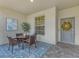 A covered outdoor patio with seating area, rug and decor in a relaxing color palette at 12470 Wellen Golf St # 108, Venice, FL 34293