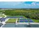 Aerial view showcasing multiple well-maintained pickleball courts with vibrant blue and red surfaces and black surrounding fences at 12470 Wellen Golf St # 108, Venice, FL 34293