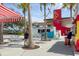 Outdoor restaurant area with palm trees, string lights, and colorful food truck-style vendor kiosks at 12470 Wellen Golf St # 108, Venice, FL 34293