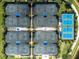 An overhead view of tennis courts showing lush tropical landscaping, and community walking path at 13859 Vadini St, Venice, FL 34293