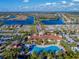 Aerial view of the community clubhouse, swimming pool, and surrounding residential area with lakes at 13859 Vadini St, Venice, FL 34293