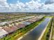 Aerial view of a waterfront property highlighting its location with a screened lanai, lush landscaping, and scenic surroundings at 13859 Vadini St, Venice, FL 34293