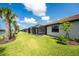 View of the rear of the home with multiple covered patios, nice yard, landscaping, and a lake at 13859 Vadini St, Venice, FL 34293
