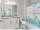 Bright bathroom with granite countertop vanity, ocean-themed shower curtain, and tile flooring at 13859 Vadini St, Venice, FL 34293