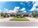 Beautiful home exterior featuring a well-manicured lawn, brick driveway, and symmetrical design with dual garage doors at 13859 Vadini St, Venice, FL 34293