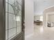 Inviting home foyer with a decorative glass door, tiled floors, and a view into the open dining and living areas at 13859 Vadini St, Venice, FL 34293