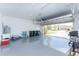 Spacious two-car garage with epoxy flooring, ample storage, and an open door revealing a glimpse of the neighborhood at 13859 Vadini St, Venice, FL 34293