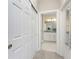 Hallway view into a bathroom with white cabinets, granite countertops, and modern lighting at 13859 Vadini St, Venice, FL 34293