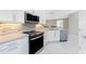 Contemporary kitchen with stainless steel appliances, white cabinets, sleek countertops, and a view into the adjacent living area at 13859 Vadini St, Venice, FL 34293