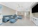 Bright living room with a large blue leather sofa, ceiling fan, and neutral walls at 13859 Vadini St, Venice, FL 34293