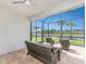 View of screened-in patio with wicker furniture including a sofa, chairs, and table at 13859 Vadini St, Venice, FL 34293