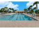 Lap pool with lane markers and lounge chairs on the pool deck under a clear blue sky at 13859 Vadini St, Venice, FL 34293