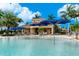 Community pool area with blue umbrellas and outdoor seating near the clubhouse at 13859 Vadini St, Venice, FL 34293