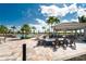 Relaxing poolside seating area featuring a pavilion with an outdoor fire pit, and lounge chairs in a bright setting at 13859 Vadini St, Venice, FL 34293
