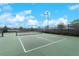 Well-maintained tennis court surrounded by lush landscaping in a residential community at 13859 Vadini St, Venice, FL 34293