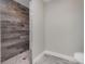Bathroom walk-in shower with mixed wood look tiling and pebble flooring at 14 Current Ln, Placida, FL 33946