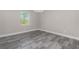 Bedroom with gray wood-look tile flooring, light gray walls, and a bright window at 14 Current Ln, Placida, FL 33946