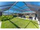 Expansive backyard featuring a screened-in pool and well-maintained lawn, perfect for outdoor activities and relaxation at 146 Rotonda Cir, Rotonda West, FL 33947