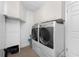 Well-equipped laundry room with modern washer, dryer, and overhead storage cabinets at 146 Rotonda Cir, Rotonda West, FL 33947