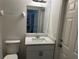 Well-lit bathroom featuring a modern vanity and a commode at 15417 Hanley Ct, Port Charlotte, FL 33953