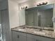 Bathroom features a double granite vanity and large mirror at 15417 Hanley Ct, Port Charlotte, FL 33953