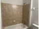 Updated bathroom with shower-tub combo and neutral-colored tiling at 15417 Hanley Ct, Port Charlotte, FL 33953