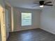 Bright bedroom featuring a ceiling fan, wood-look flooring and a window overlooking the backyard at 15417 Hanley Ct, Port Charlotte, FL 33953