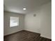 Bright bedroom with wood-look flooring and a large window, offers a cozy retreat at 15417 Hanley Ct, Port Charlotte, FL 33953