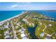 A beautiful aerial view of the coastline with stunning turquoise water, beaches, and waterfront homes at 180 N Gulf Blvd # 5, Placida, FL 33946