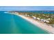 A beautiful aerial view of the coastline with stunning turquoise water, beaches, and waterfront homes at 180 N Gulf Blvd # 5, Placida, FL 33946
