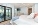 Light and airy bedroom with balcony access, TV, and ensuite bathroom with marble shower at 180 N Gulf Blvd # 5, Placida, FL 33946