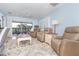Comfortable living room with recliners, ceiling fan, and a view of the screened porch at 180 N Gulf Blvd # 5, Placida, FL 33946