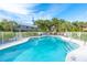 Community pool area with ample seating and lush tropical landscaping surrounding the fenced in area at 180 N Gulf Blvd # 5, Placida, FL 33946