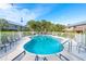 Community pool area with ample seating and lush tropical landscaping surrounding the fenced in area at 180 N Gulf Blvd # 5, Placida, FL 33946