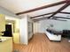 Open floorplan with living and kitchen areas featuring wood floors and exposed beams at 22589 Nyack Ave, Port Charlotte, FL 33952